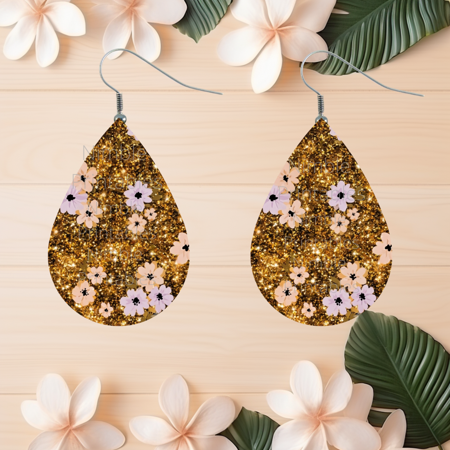 Teardrop earrings with gold glitter and floral print on wood.