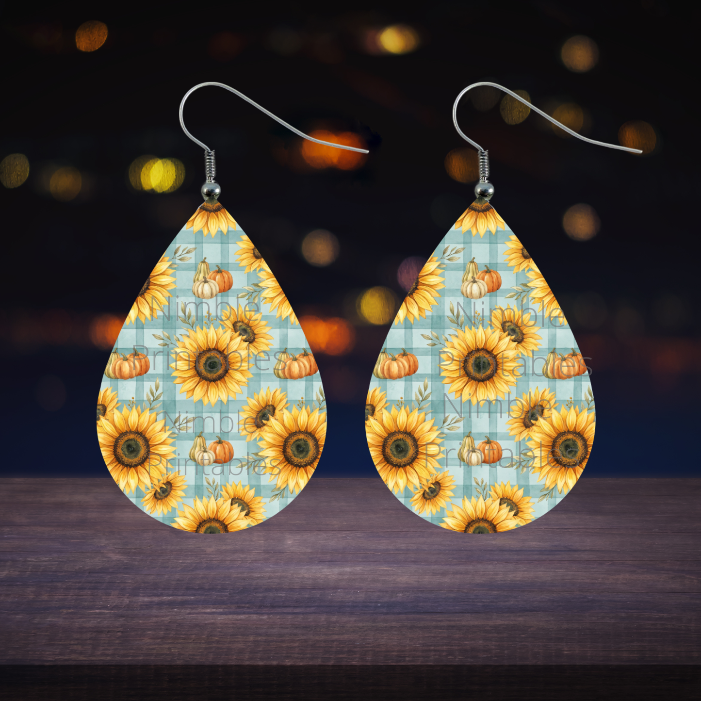 Teardrop earrings with sunflowers and pumpkins on a blue plaid background.
