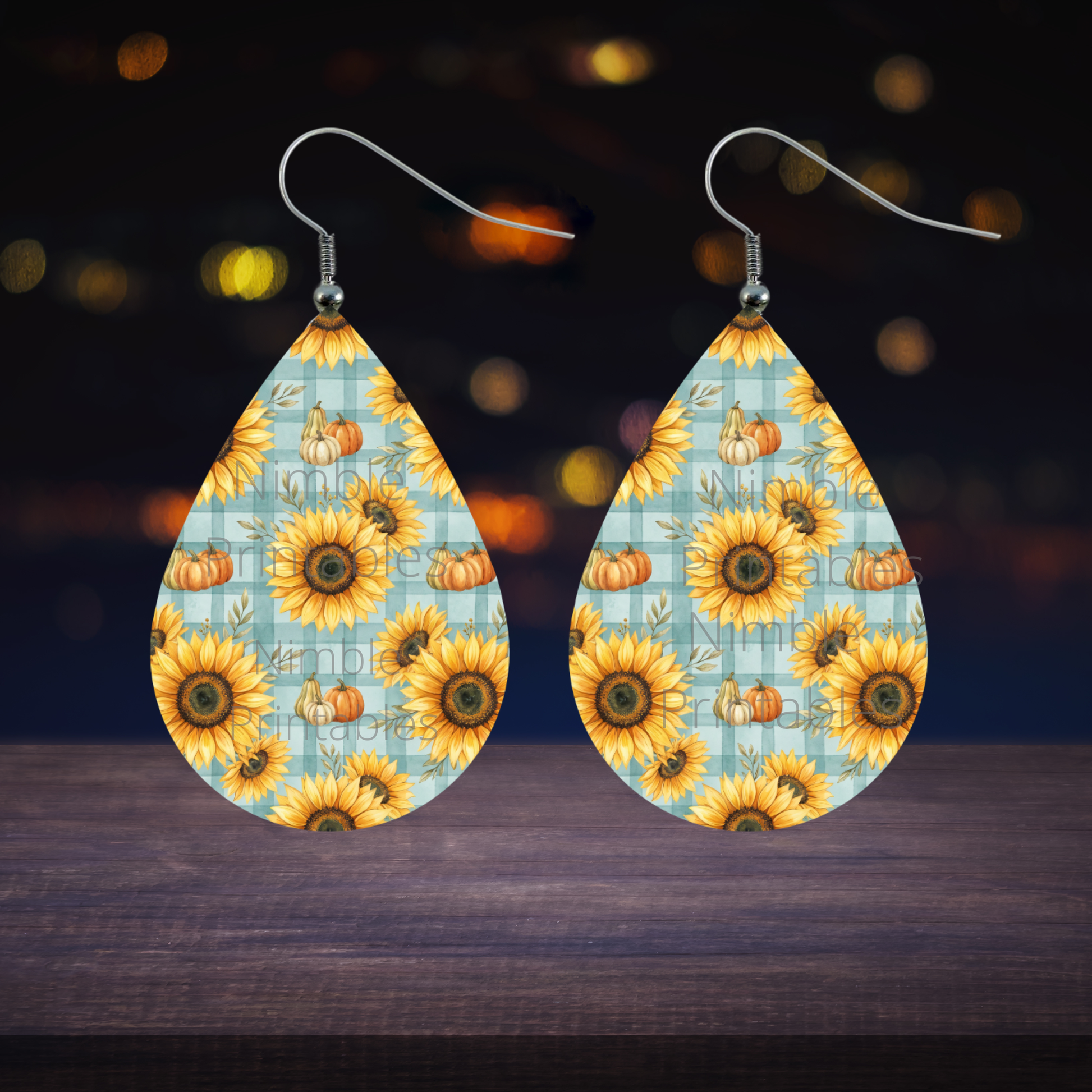 Teardrop earrings with sunflowers and pumpkins on a blue plaid background.