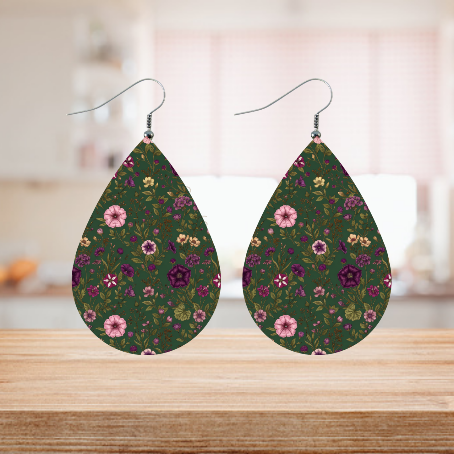 Teardrop earrings with a dark green background and a purple and pink floral pattern.