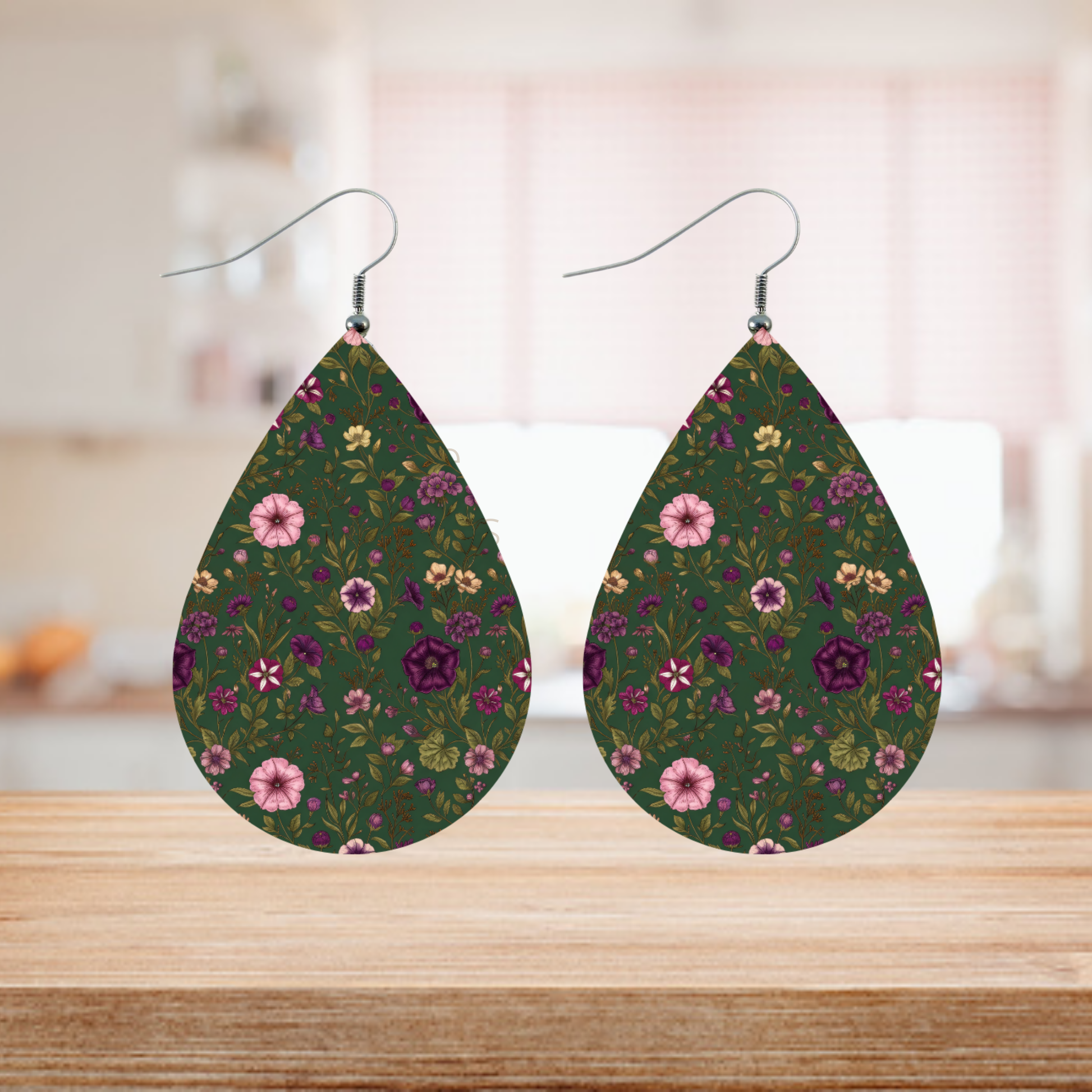 Teardrop earrings with a dark green background and a purple and pink floral pattern.